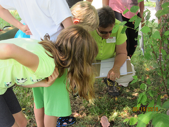 EMG volunteer teaching kids about plants.