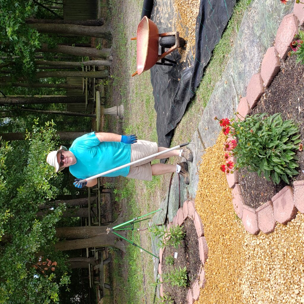 man holding rake working in a garden