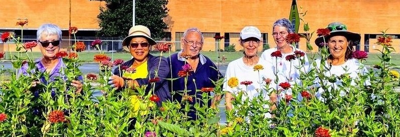 Volunteers standing in front of a bed of flowers